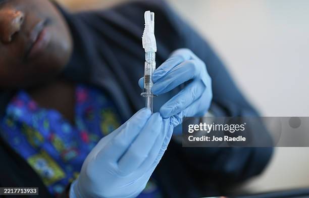 In this photo illustration, Ruth Jones, Immunization Nurse, holds a Pfizer-BioNTech COVID-19 vaccine at Borinquen Health Care Center on May 29, 2025...