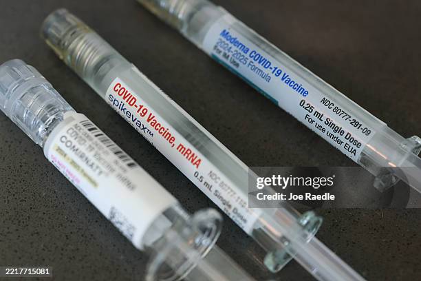 In this photo illustration, Pfizer-BioNTech COVID-19 and Moderna COVID-19 vaccines fill their syringes at Borinquen Health Care Center on May 29,...