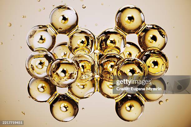 golden cosmetic serum bubbles forming a complex structure - molecular structure stock pictures, royalty-free photos & images