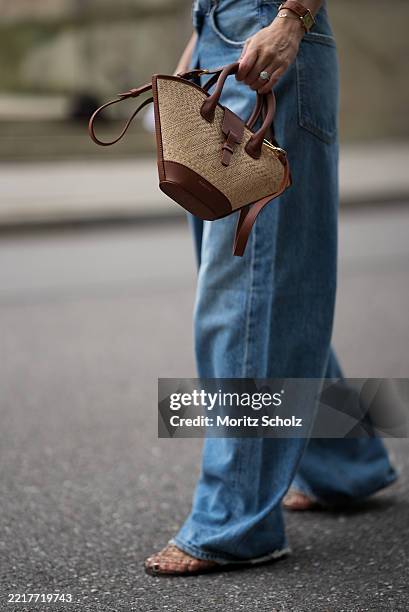 Marlies Pia Pfeifhofer is seen wearing wearing a mid blue wide leg Vana Fold jeans with "fold" closure from AGOLDE, a pair of transparent cut-out...