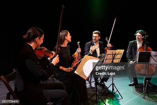 talented musicians rehearse a performance on the theater stage. there is a positive atmosphere during the rehearsal - orchestra rehearsal stock pictures, royalty-free photos & images