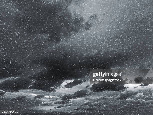 heavy rain falling from dark storm clouds in dramatic weather - lluvia torrencial fotografías e imágenes de stock