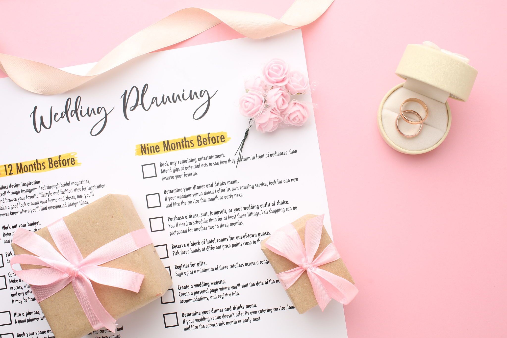 Wedding to-do list top view. Gift boxes, wedding planning calendar and various wedding trivia on a pink rustic table. Background for organising the commemorative date Wedding to-do list top view. Gift boxes, wedding planning calendar and various wedding trivia on a pink rustic table. Background for organising the commemorative date