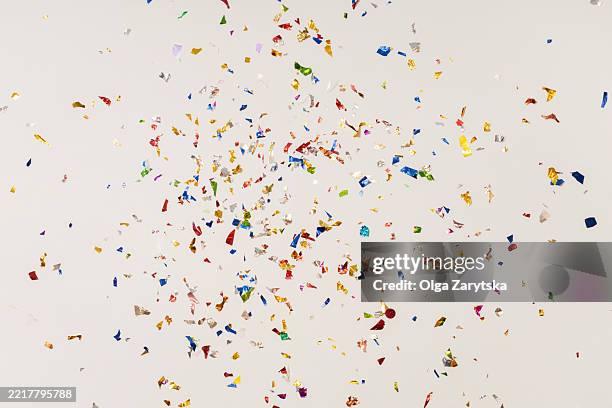 multi colored foil confetti on white background - confetti stock pictures, royalty-free photos & images