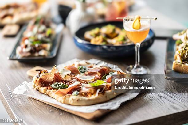 pizza and other types of food along with drinks on a table in a pizzeria or restaurant. - cheese pizza stock pictures, royalty-free photos & images