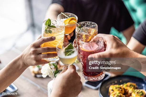 a group of friends enjoying a meeting, toasting with cotails - cocktailfeest stockfoto's en -beelden