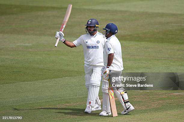 Karun Nair of India A is congratulated by Sarfaraz Khan as he acknowledges the crowd after reaching his half century during the four day match...