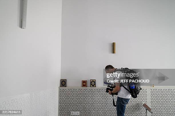 An AFP video journalist films Koran books displayed inside the prayer room of the Errahma mosque in Villeurbanne, central France, on June 3, 2025. A...