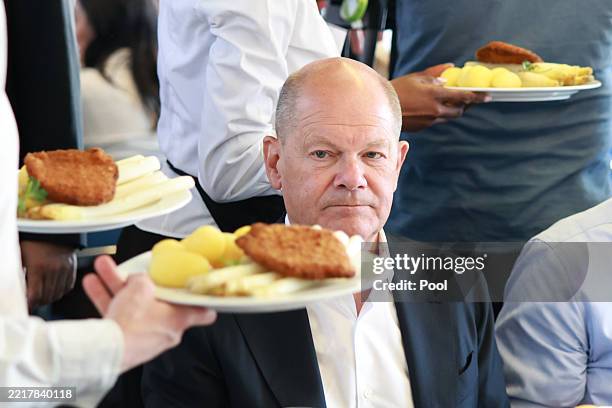 Former German Chancellor Olaf Scholz is served with asparagus during the meeting of the SPD parliamentary group at the 64th Seeheim Asparagus Tour on...