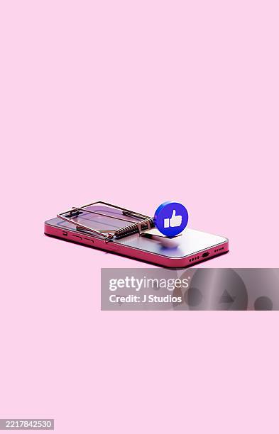 smartphone-based mousetrap with social media like icon as bait symbolizing digital addiction and online approval risks - image based social media stockfoto's en -beelden