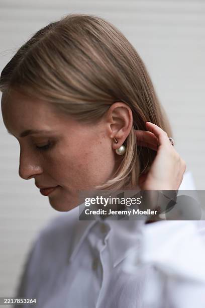 Marlies Pia Pfeifhofer is seen wearing a large pearl earring on a straight metal pin from Dior, a white shirt blouse with a large collar from Aeris,...