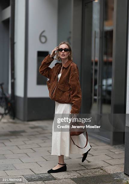 Marlies Pia Pfeifhofer is seen wearing oval tortoiseshell-framed sunglasses from Corlin, gold hoop earrings from Ole Lynggaard, a gold pendant...