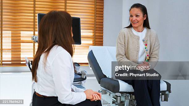 female doctor consulting patient during ultrasound examination in modern clinic - colposcopy stock pictures, royalty-free photos & images