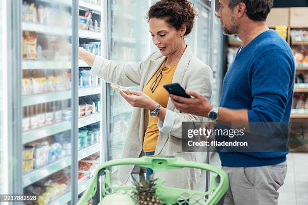 couple shopping in supermarket. - buy online pick up in store stock pictures, royalty-free photos & images