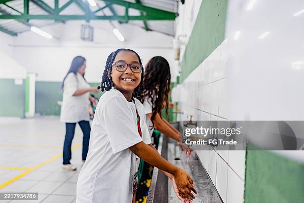 portrait d’une écolière se lavant les mains à l’école - écolière photos et images de collection