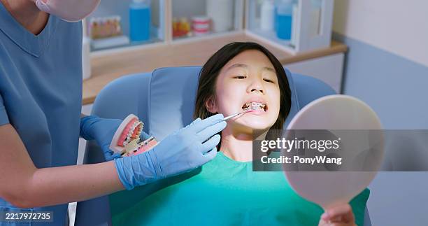 il dentista asiatico usa il modello di denti a filo spiegare - ortodonzia foto e immagini stock