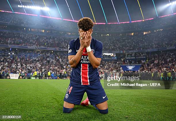 Desire Doue of Paris Saint-Germain appears emotional as he drops to his knees in celebration after his team's victory in the UEFA Champions League...