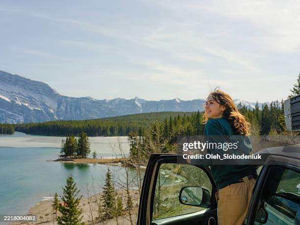 donna che guarda il lago panoramico a banff durante il viaggio su strada con suv in primavera - viaggio in macchina foto e immagini stock