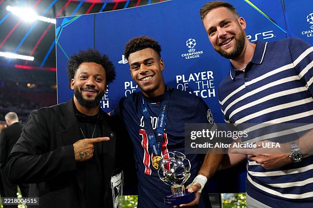 Former Real Madrid player Marcelo poses for a photograph with Desire Doue of Paris Saint-Germain after he is presented with the PlayStation Player of...