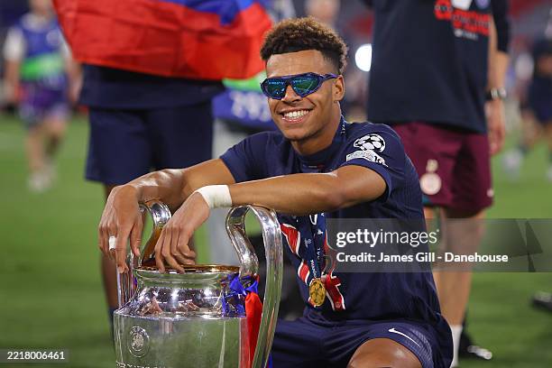 Desire Doue of Paris Saint-Germain poses with the UEFA Champions League trophy after his team's victory, to secure Paris Saint-Germain's first ever...