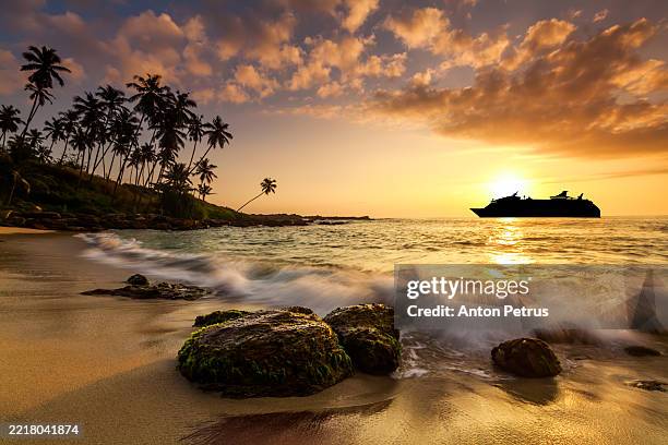 cruise ship at sunset near the shores of a tropical island - indie occidentali foto e immagini stock