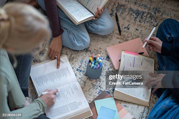 sesión de estudio en grupo con libros abiertos y materiales coloridos para marcar - teología fotografías e imágenes de stock