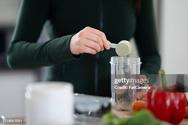 preparing a nutritional smoothie with fresh vegetables and health supplement - superfood stock pictures, royalty-free photos & images