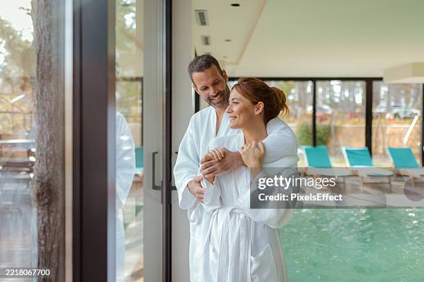 ruhiger spa-moment - paar, das sich am pool umarmt - wellness stock-fotos und bilder