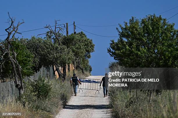 Portuguese Investigation Police officers carry a barrier amid the investigation into the disappearance of Madeleine McCann in Lagos' neighbourhood of...