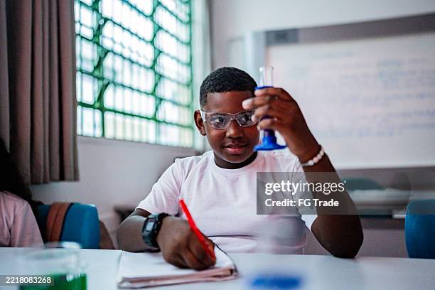 schoolboy doing scientific experiment in the classroom - kid science project stock pictures, royalty-free photos & images