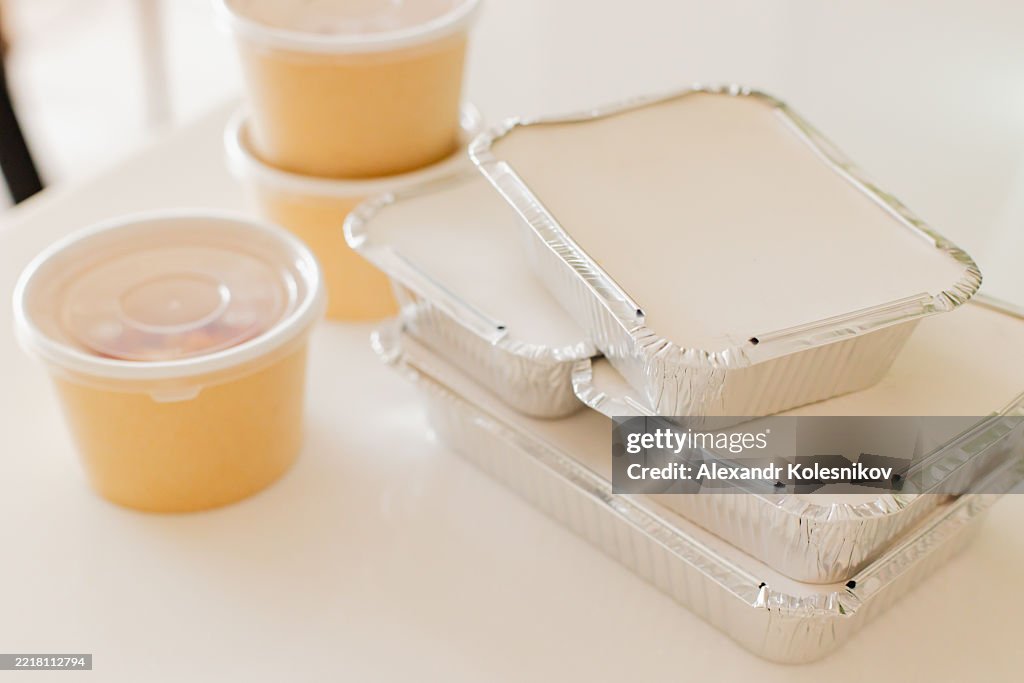 Assorted Food Containers with Plastic Cups on a White Table