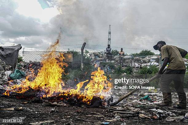 An informal waste worker burns a mattress to retrieve metal wires at Gioto dumpsite. Waste pickers play a vital role in supporting the circular...