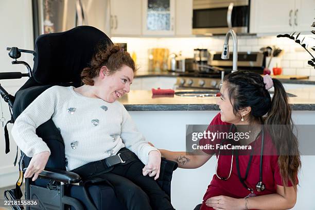 agent de santé aidant un enfant en fauteuil roulant à domicile - occupational therapy kitchen photos et images de collection