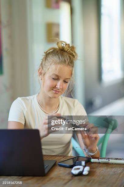 mujer joven que controla la diabetes usando pluma de insulina y dispositivos médicos en casa - hipoglicemia fotografías e imágenes de stock
