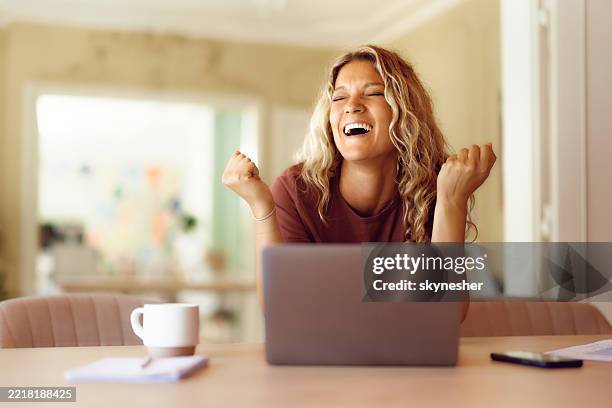 cheerful woman celebrating success at home office. - boa notícia imagens e fotografias de stock