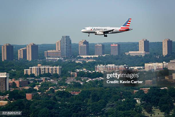 An American Airlines Airbus A319 airplane approaches Ronald Reagan Washington National Airport for a landing with high rises in Arlington, VA in the...