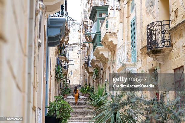 woman walks steps in old town, valetta - valletta stock pictures, royalty-free photos & images