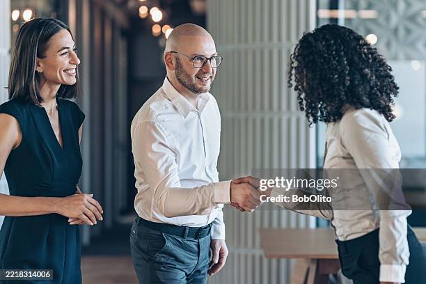 business persons shaking hands in modern office space - customer focused stock pictures, royalty-free photos & images