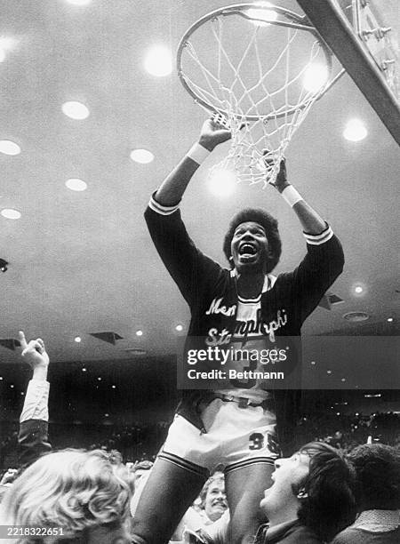 Memphis State's Larry Kenon grabs a the net for a souvenir after his team won the 1st place int the NCAA Midwest Basketball tournament by beating...