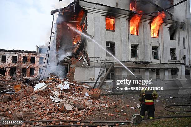 Firefighter extinguishes a fire at a civilian plant following powerful attacks to Ukrainian city of Kharkiv early on June 7, 2025. Russia pummelled...