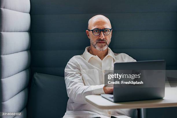 focused professional working on laptop in a modern office environment - computer equipment stock pictures, royalty-free photos & images