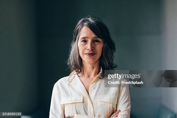 confident woman in a light blouse posing with a calm expression - portret stockfoto's en -beelden