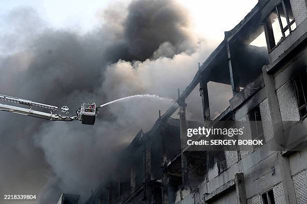 Firefighter extinguishes a fire at a civilian plant following Russian powerful attacks on the Ukrainian city of Kharkiv early on June 7 amid the...