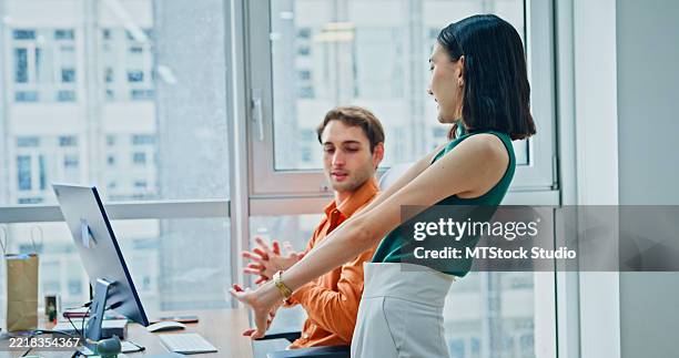 group of diverse colleagues in casual clothing taking a break practicing stretching exercises to promote wellbeing and an active lifestyle in modern office. sustainable business and finance. - good posture at desk stock pictures, royalty-free photos & images
