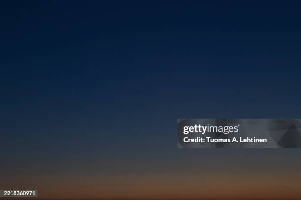 orange and dark blue cloudless sky in the evening. - dramatic light stock pictures, royalty-free photos & images