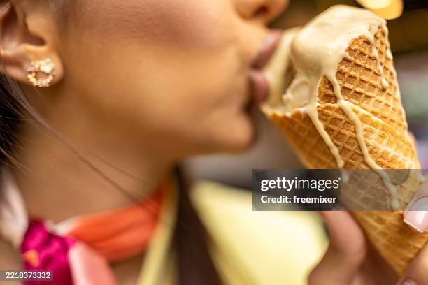 disfrutando de un helado en la ciudad - una sola mujer joven fotografías e imágenes de stock
