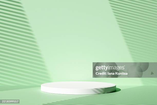 minimalist green 3d scene with round white podium and dramatic light shadows from window blinds. perfect for product display, branding, or modern presentation backgrounds. - iluminación gobo fotografías e imágenes de stock