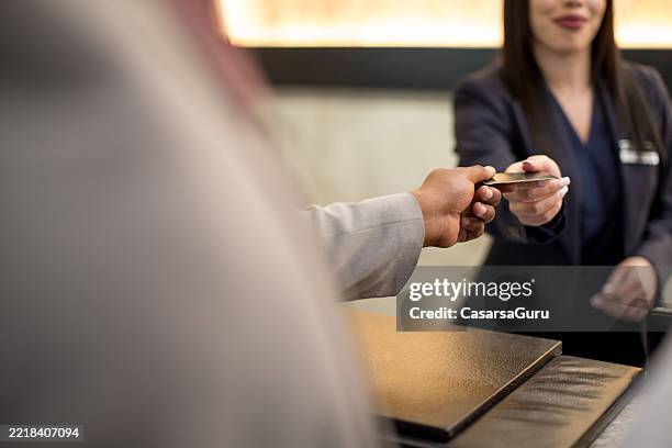hotel guest receiving a card key from the receptionist at the check-in - hotel key stock pictures, royalty-free photos & images