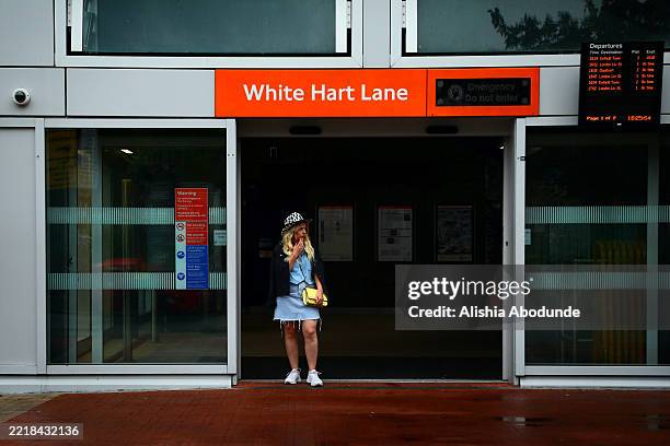 Fan shields from the rain inside the doorway of White Hart Lane station ahead of Beyonce's second performance at Tottenham Hotspur Stadium on June 7,...
