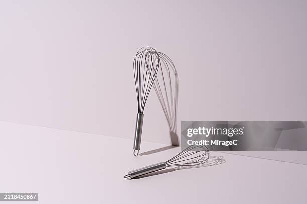 stainless steel wire whisk on beige background - fouet manuel photos et images de collection